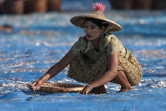 Burmese woman with straw hat and Thanaka paste in the face