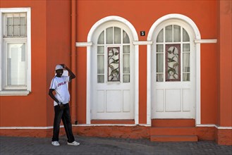 Local man standing in front of a colonial building
