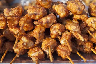Grilled meat skewers on sale at a market