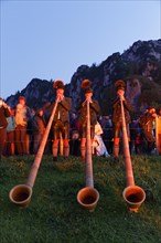 Alphorn players in the glow of bonfires