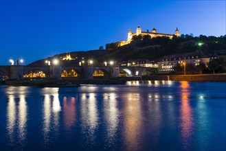 The illuminated Festung Marienberg castle located on a hill above the town