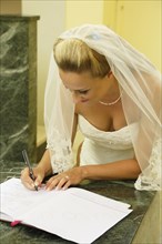 Bride signing the church register after the ceremony