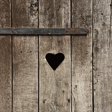 Weathered wooden door with a heart