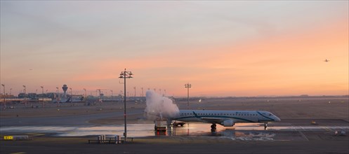 Aircraft de-icing at sunrise
