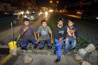 Group of street children on the roadside at night