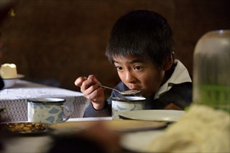 Boy eating soup with quinoa