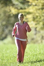 Young woman jogging on a meadow