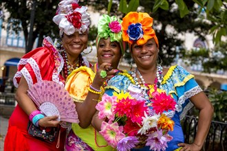 Three Cuban women in colorful Spanish-inspired costumes