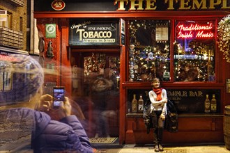Man taking a photo of a woman in front of The Temple Bar