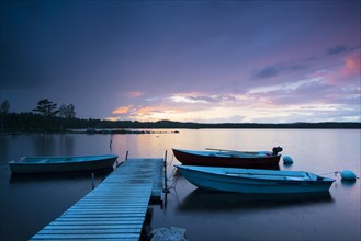 Boats at the jetty at sunset on lake Skarvsjo