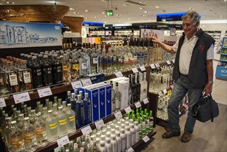Various spirits and a tourist in the duty-free shop