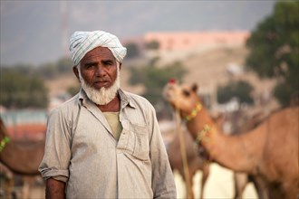 Rajasthani wearing traditional dress with camel at the Pushkar Mela camel and livestock fair