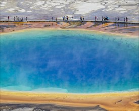 Tourists standing on the edge of Grand Prismatic Spring
