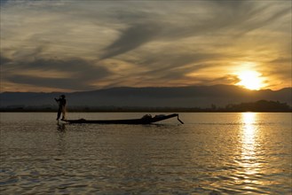 Leg-rowing fisherman on Inle lake at sunset