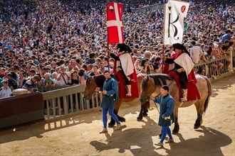 Parade of flag carriers on horses at the historical parade before the Palio di Siena horse race