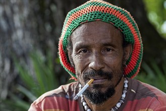Local man with a rasta hat smoking a cigarette