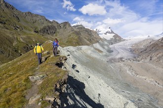 A man and a woman hiking on the moraine of the Findel Glacier at Fluhalp