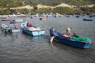 Fishermen in their fishing boats unloading their catch