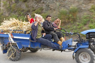 Farmers travelling on a tractor