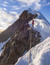 Roped alpinist on the mountain ridge