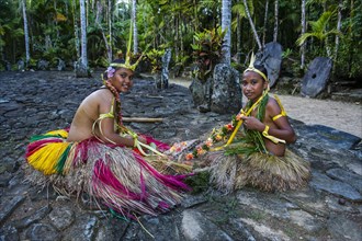 Traditionally dressed islanders making traditional art work