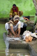 Woman washing laundry by the river