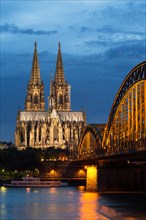 Cologne Cathedral with Hohenzollern Bridge at dusk