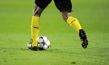 Legs of a football player from Borussia Dortmund with the official UEFA Champions League football ""Adidas Finale""