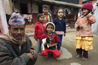 Nepalese father and children in front of their house