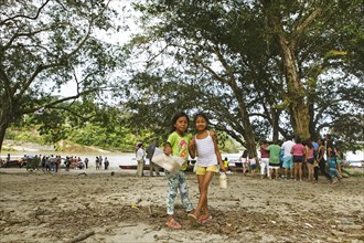 Girls selling sugar cane on the jungle beach of Misahualli
