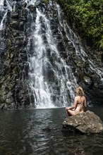 Woman sitting in front of the Kepirohi waterfall