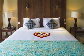 Hotel bed decorated with flower petals