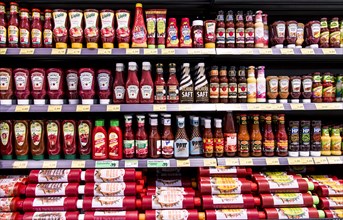 Shelf with various ketchups and sauces