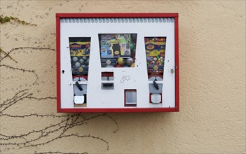 Old chewing gum vending machine on a house wall