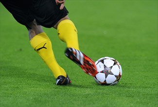 Legs of a BVB player with adidas Champions League Ball