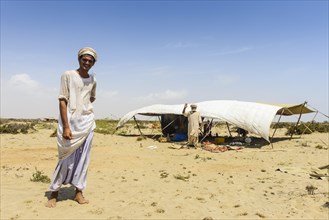 Rashaida man standing in front of his tent in the desert around Massaua