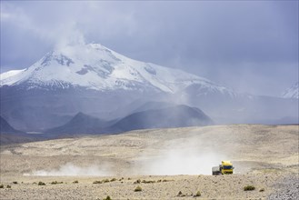 Guallatiri volcano with a a truck en route to the Salar de Surire