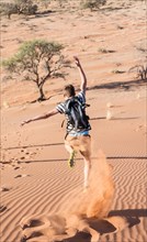 Teenager running down a dune