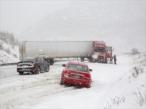A jackknifed truck blocks the westbound lanes of Interstate 70 during a snow storm in the Rocky Mountains