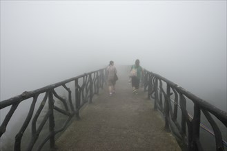 Two women on hiking trail in the fog