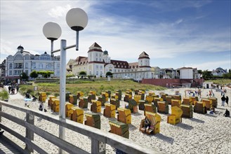 Roofed wicker beach chairs in front of the Kurhaus spa building