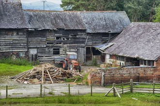 Derelict farmyard with old farm buildings and tractor