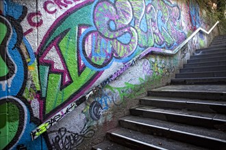 A dark staircase with graffiti