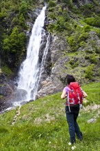Female hiker standing in front of the Partschingser Wasserfall waterfall