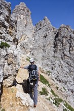 Mountain climber ascending to the summit of Plattkofel Mountain via the Oskar-Schuster climbing route