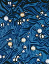 Christmas baubles lying on a blue silk cloth
