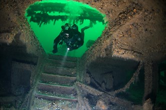 Diver at the stairs leading to the lower deck of the shipwreck of the Austrian wheel steamship 'Durnstein'