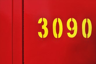 Yellow number 3090 on red