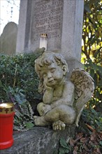 Putto and votive candle with autumn leaves on the Ostfriedhof or East Cemetery