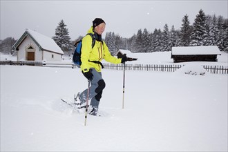 Snowshoe hiker walking on a trail to Hoher Kranzberg mountain